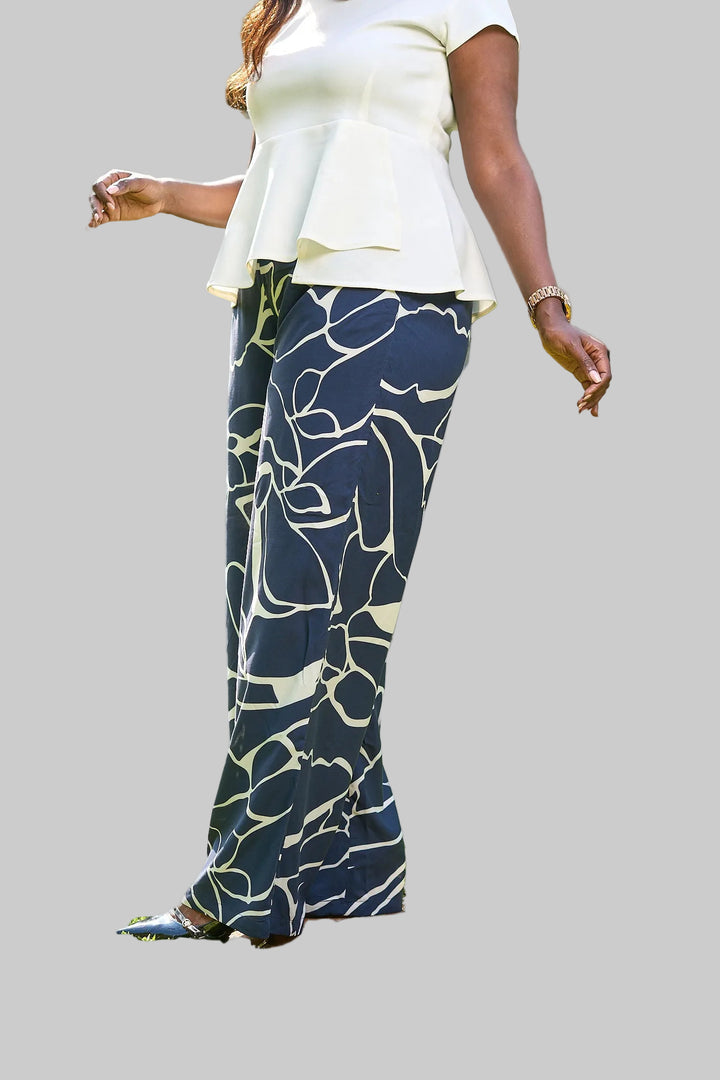 Person wearing a white top and blue patterned pants on a blurred background