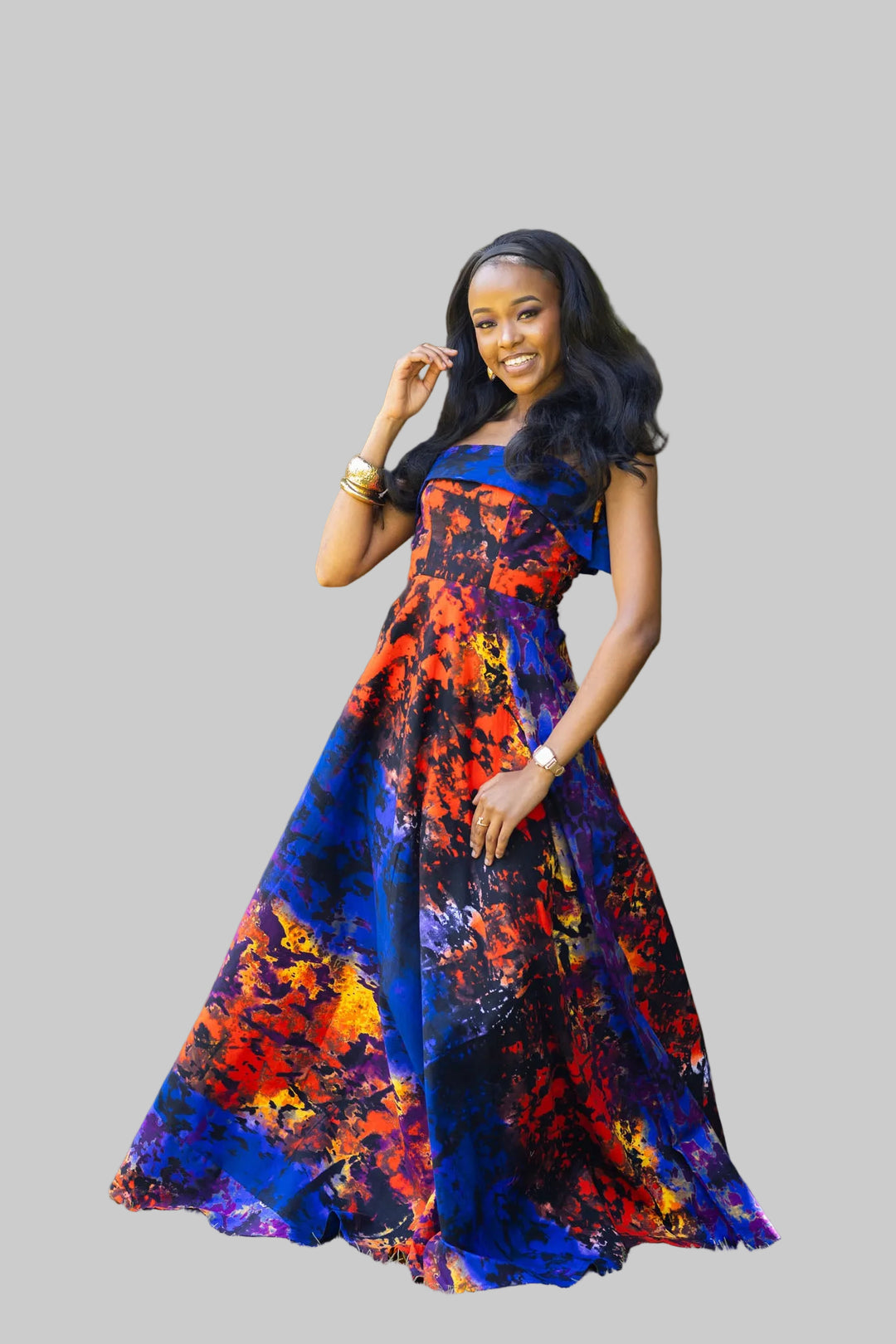 Woman in a colorful dress standing outdoors with greenery in the background